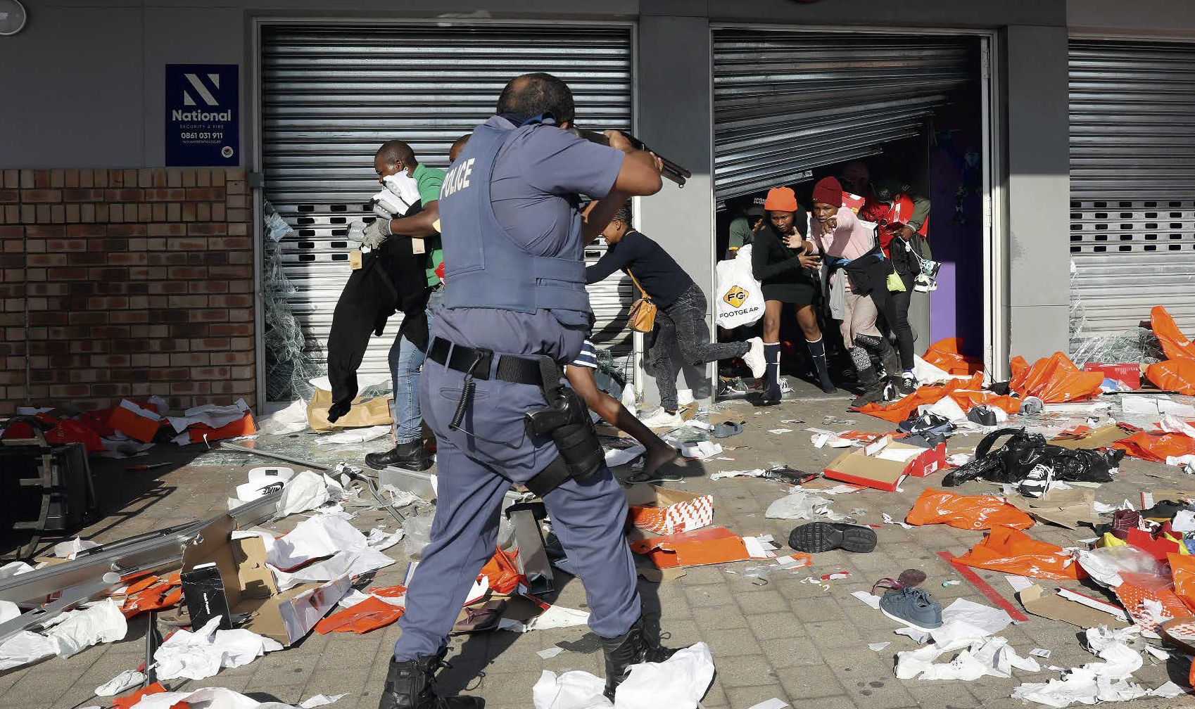 A policeman tries to control looting during a riot in Durban, July 12, 2021. EPA / EFE