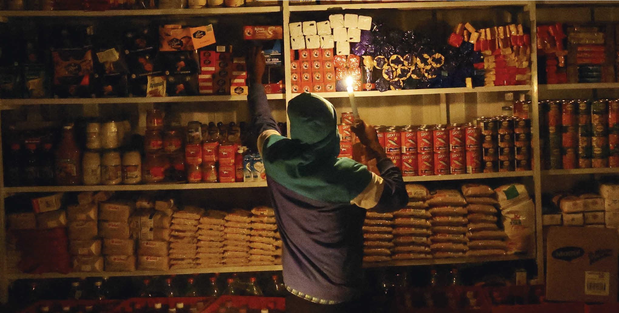 A trader in his store during a power cut, in Soweto, in April 2022. SIPHIWE SIBEKO / REUTERS
