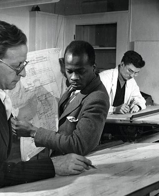 Maxwell Fry dans ses bureaux de Londres, aux côtés de l’architecte sierra-léonais John Noah.VICTORIA AND ALBERT MUSEUM