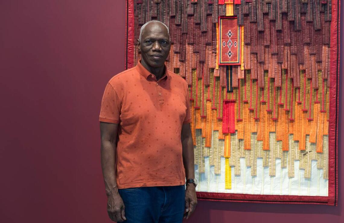 Abdoulaye Konaté : « Il est primordial de présenter notre art sur le continent et de collaborer avec des galeries africaines » L'artiste devant son oeuvre : motif Arkila kerka-tiangles et carrés sur fond ocre, 2024, galerie Farah Fakhri. JIHANE ZORKOT