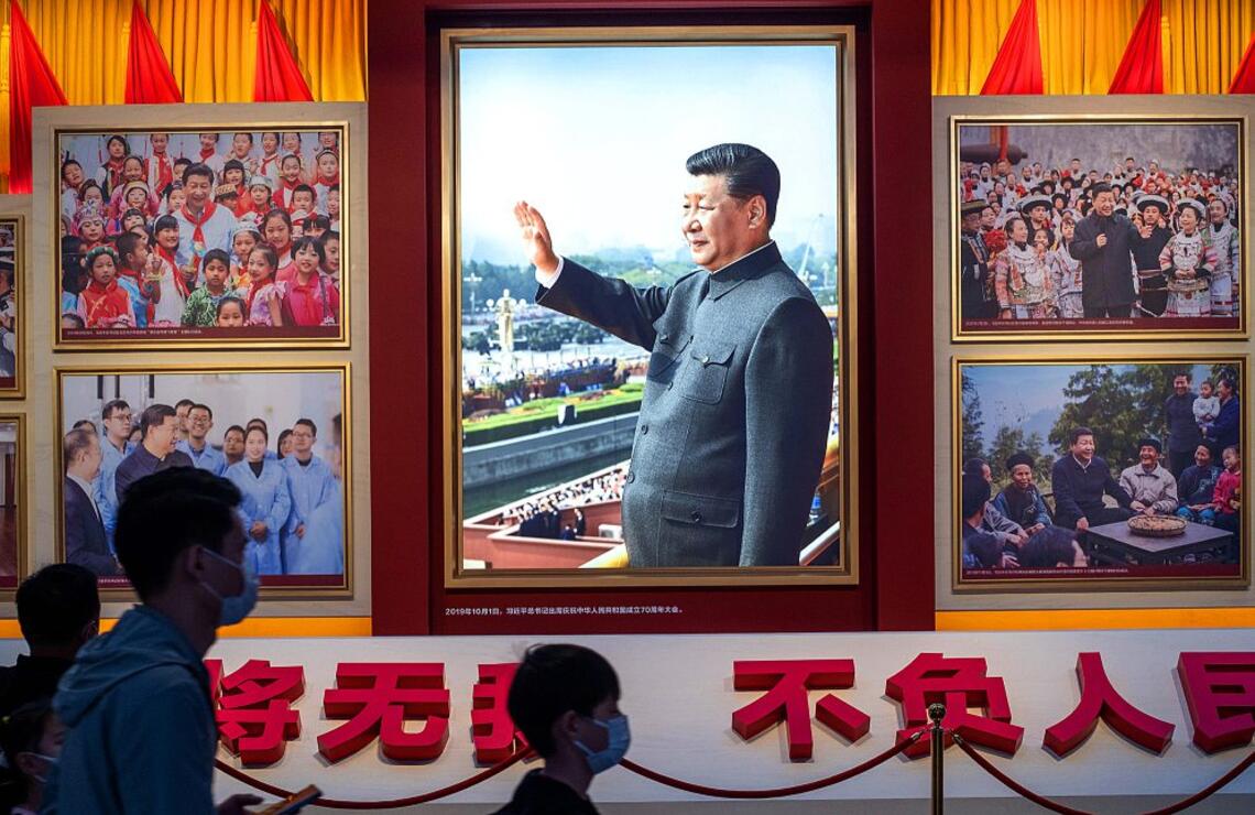 Des visiteurs du musée du Parti communiste chinois de Pékin passent devant des images où figure le président Xi Jinping. ALAMY