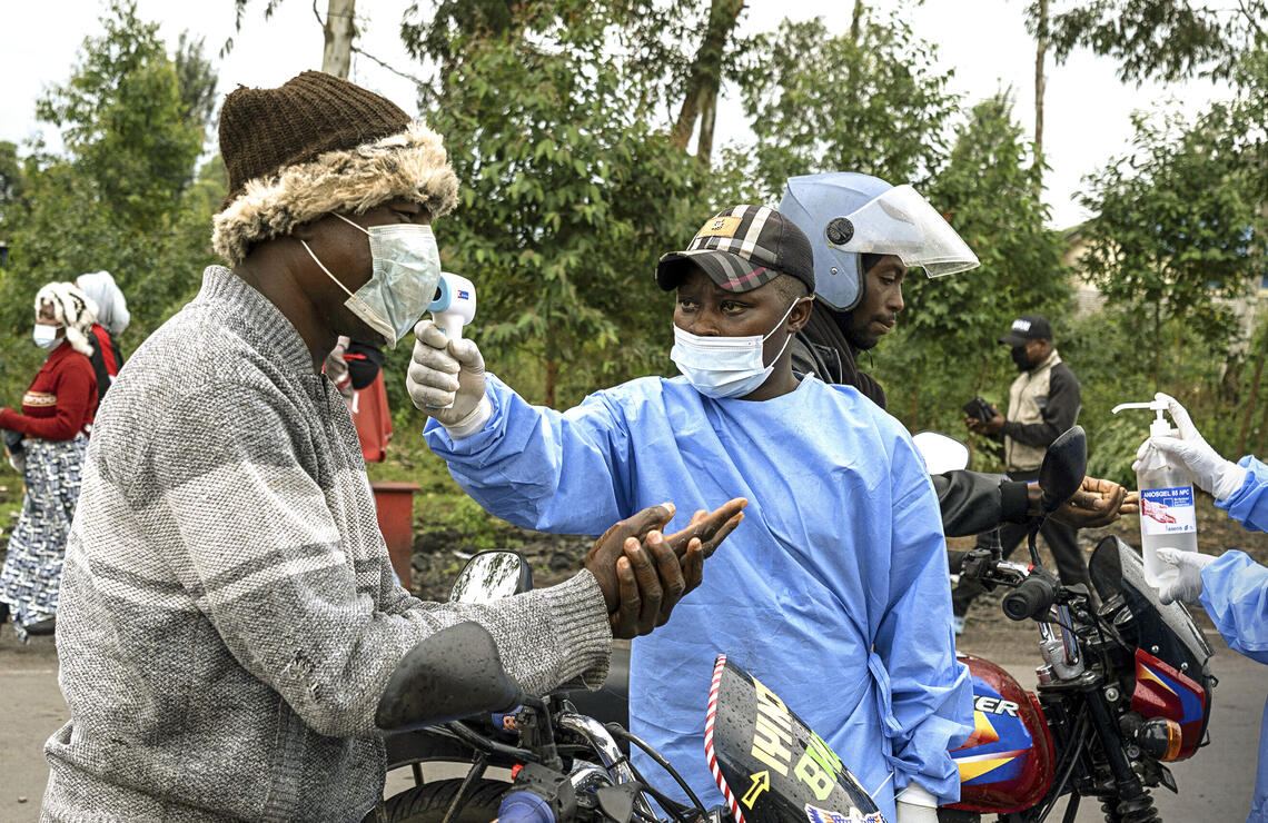 Des praticiens de santé déployés au camp de Kanyaruchinya, en RDC, contrôlent la température des motocyclistes et leur fournissent du gel hydroalcoolique, le 21 mai 2026. ARLETTE BASHIZI/THE NEW YORK TIMES-REDUX-REA