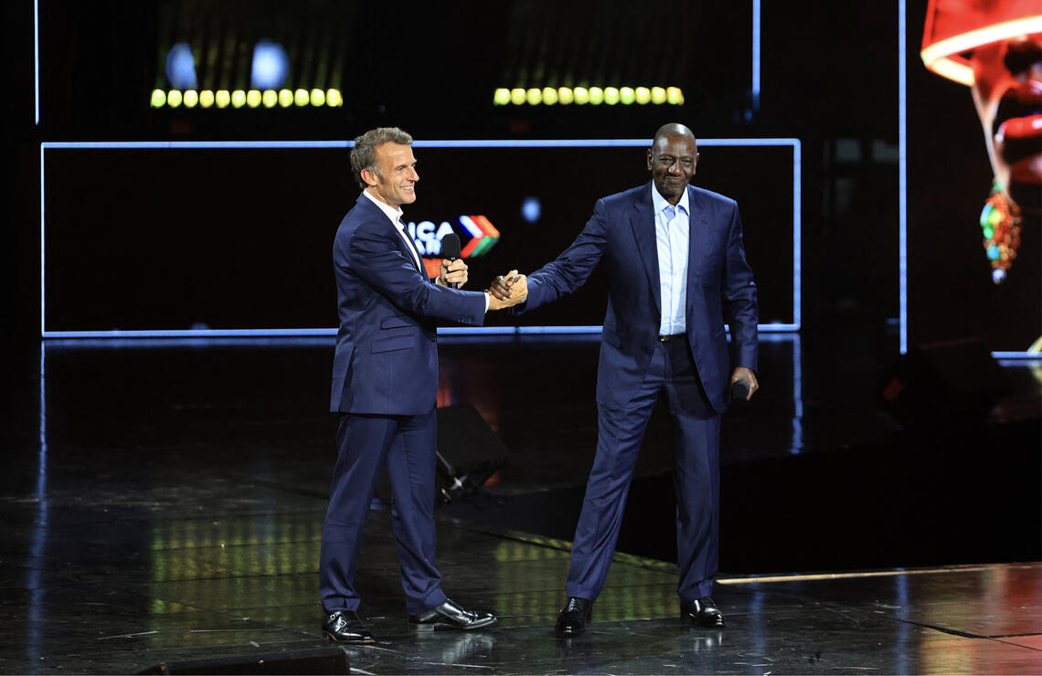 Poignée de main entre le président français Emmanuel Macron et le président kényan William Ruto avant le début du concert de clôture du sommet Africa Forward, le 12 mai 2026, au Kasarani Indoor Arena, à Nairobi. LUDOVIC MARIN/AFP