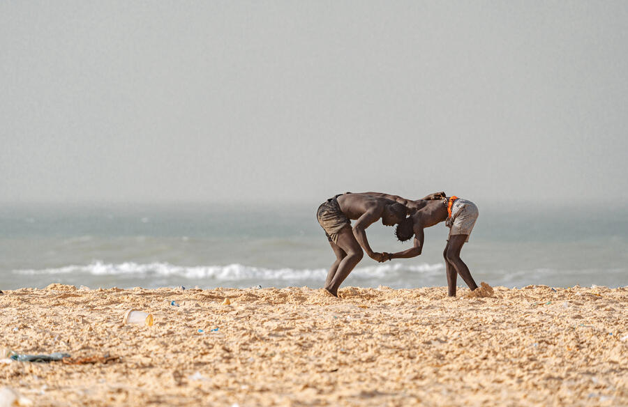 Deux jeunes hommes pratiquent la lutte sur les berges du lac Rose, au Sénégal. SHUTTERSTOCK