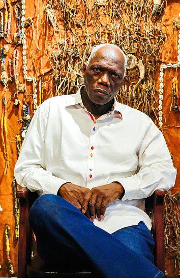 Abdoulaye Konaté pose devant son oeuvre inédite Hommage aux chasseurs du Mandé #4, présentée lors de la Biennale par la OH Gallery.